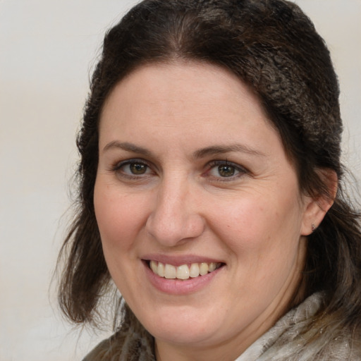 Joyful white adult female with medium  brown hair and grey eyes