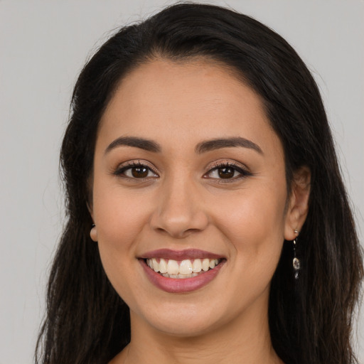 Joyful latino young-adult female with long  brown hair and brown eyes