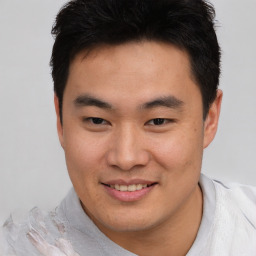 Joyful asian young-adult male with short  brown hair and brown eyes