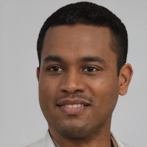 Joyful black young-adult male with short  black hair and brown eyes