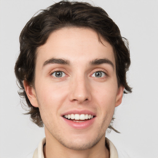 Joyful white young-adult male with short  brown hair and green eyes