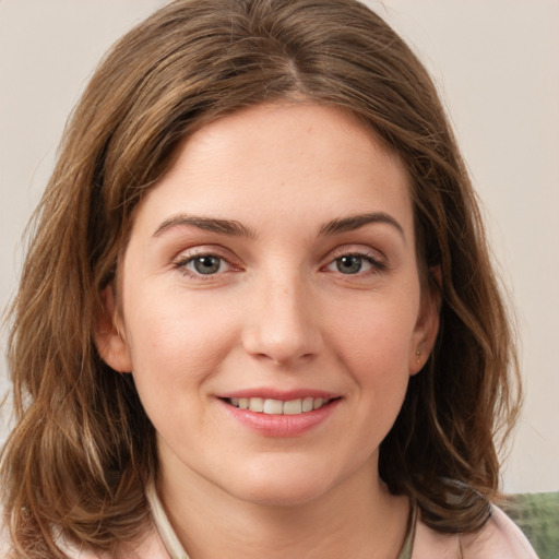 Joyful white young-adult female with medium  brown hair and green eyes