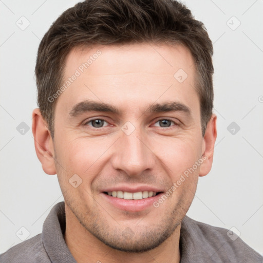 Joyful white young-adult male with short  brown hair and grey eyes