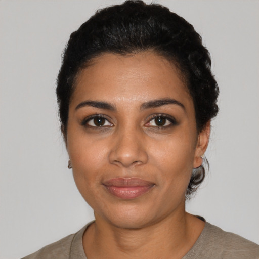 Joyful black young-adult female with short  black hair and brown eyes