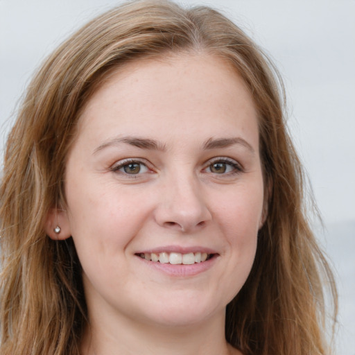 Joyful white young-adult female with long  brown hair and green eyes