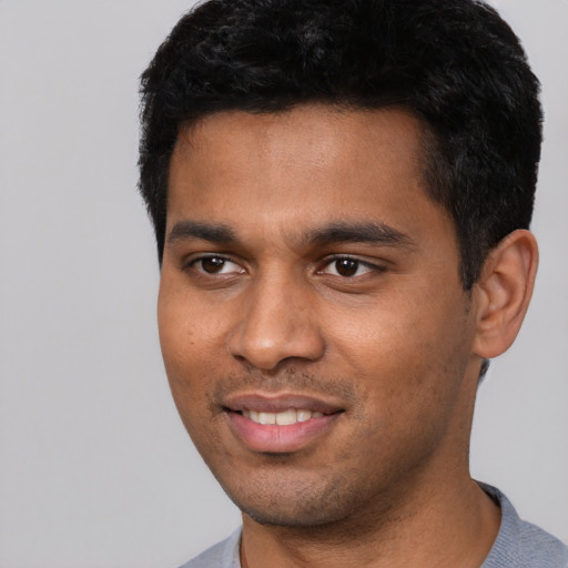 Joyful black young-adult male with short  black hair and brown eyes