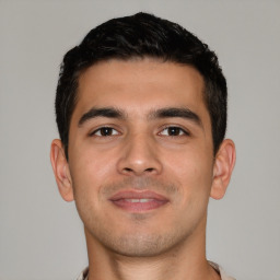 Joyful white young-adult male with short  black hair and brown eyes