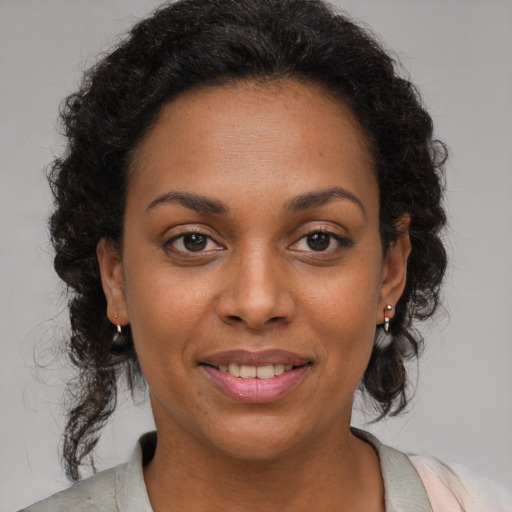 Joyful black young-adult female with medium  brown hair and brown eyes