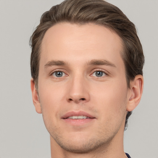 Joyful white young-adult male with short  brown hair and grey eyes