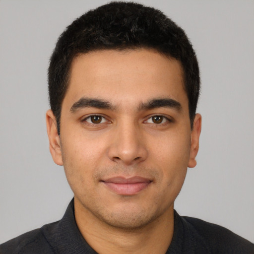 Joyful latino young-adult male with short  brown hair and brown eyes