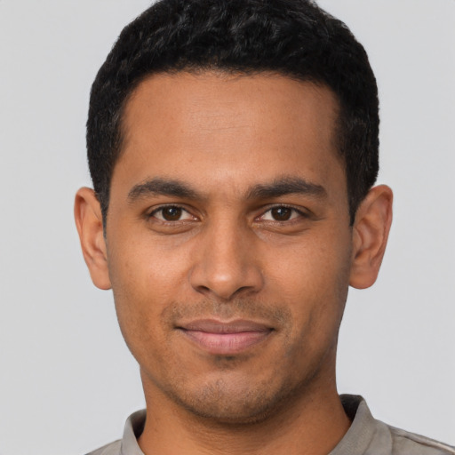 Joyful latino young-adult male with short  black hair and brown eyes