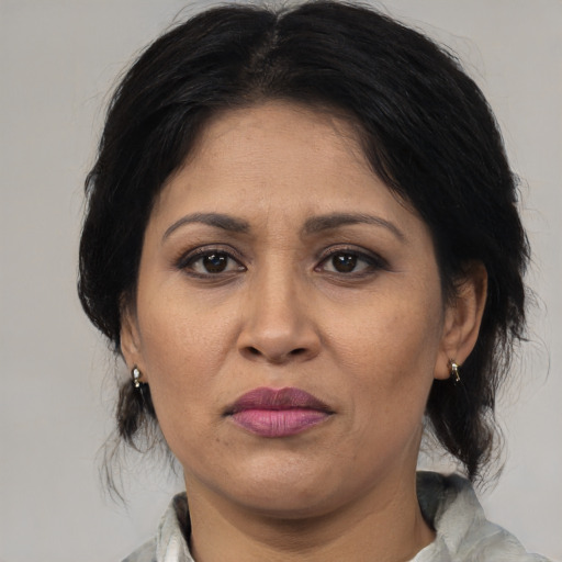 Joyful latino adult female with medium  brown hair and brown eyes