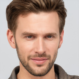 Joyful white young-adult male with short  brown hair and grey eyes