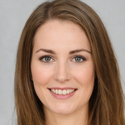 Joyful white young-adult female with long  brown hair and green eyes