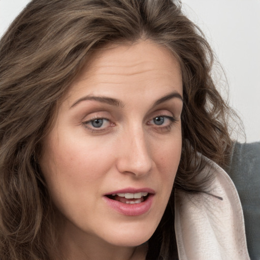 Joyful white young-adult female with long  brown hair and blue eyes