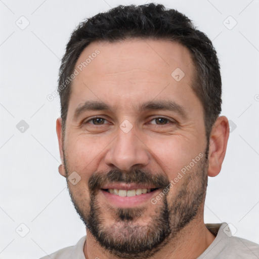 Joyful white adult male with short  black hair and brown eyes