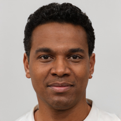 Joyful black young-adult male with short  black hair and brown eyes