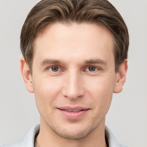 Joyful white young-adult male with short  brown hair and grey eyes