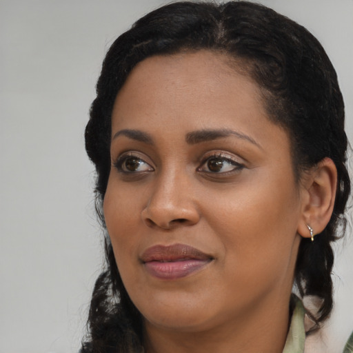 Joyful black young-adult female with long  brown hair and brown eyes