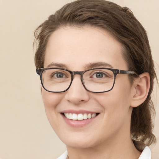 Joyful white young-adult female with medium  brown hair and green eyes