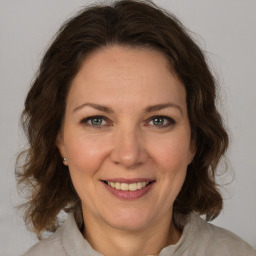 Joyful white adult female with medium  brown hair and grey eyes