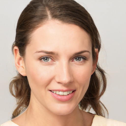 Joyful white young-adult female with medium  brown hair and grey eyes