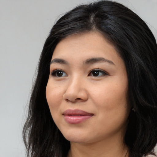 Joyful asian young-adult female with long  black hair and brown eyes