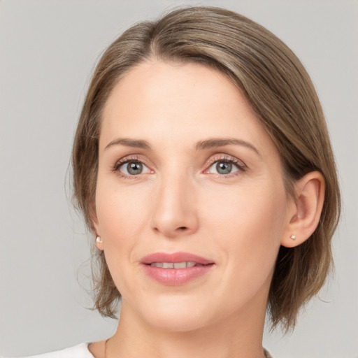 Joyful white young-adult female with medium  brown hair and grey eyes