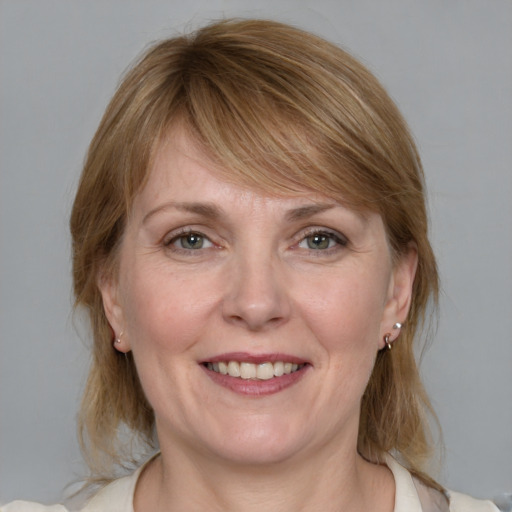 Joyful white adult female with medium  brown hair and blue eyes