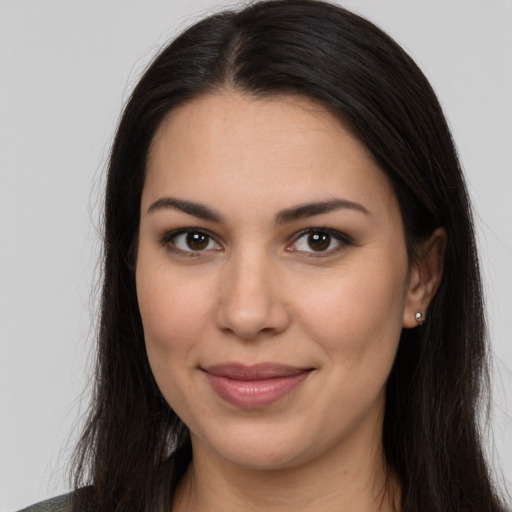 Joyful latino young-adult female with long  brown hair and brown eyes