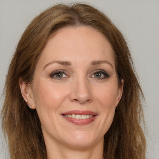 Joyful white adult female with long  brown hair and grey eyes