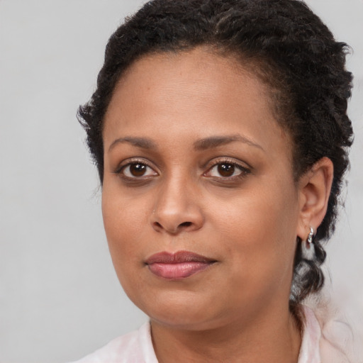 Joyful black young-adult female with medium  brown hair and brown eyes