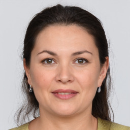 Joyful white adult female with medium  brown hair and grey eyes