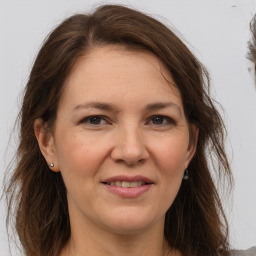 Joyful white adult female with long  brown hair and brown eyes