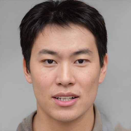 Joyful asian young-adult male with short  brown hair and brown eyes