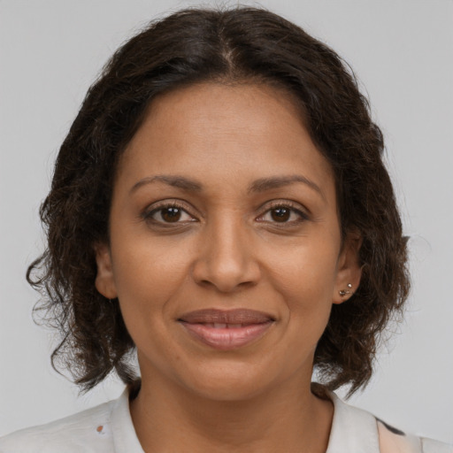 Joyful black young-adult female with medium  brown hair and brown eyes