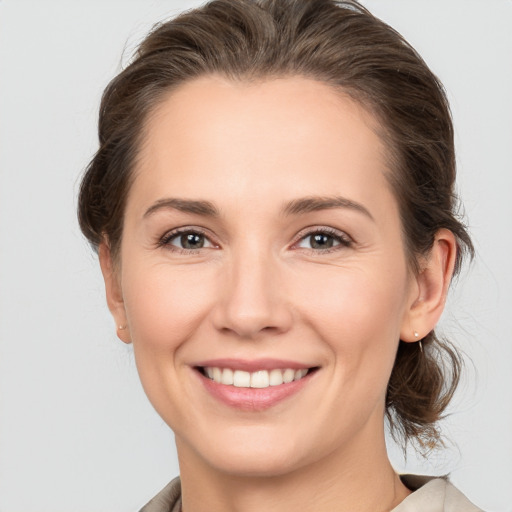 Joyful white young-adult female with medium  brown hair and grey eyes