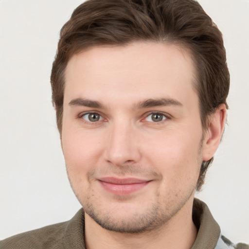 Joyful white young-adult male with short  brown hair and grey eyes