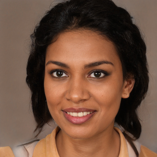 Joyful black young-adult female with long  brown hair and brown eyes