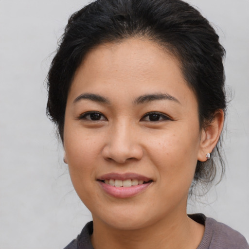 Joyful latino young-adult female with medium  brown hair and brown eyes