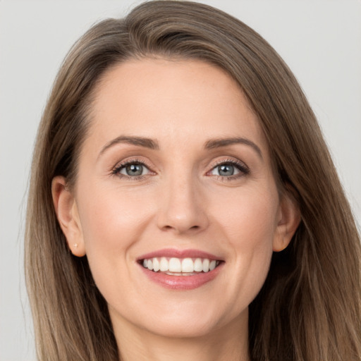 Joyful white young-adult female with long  brown hair and grey eyes