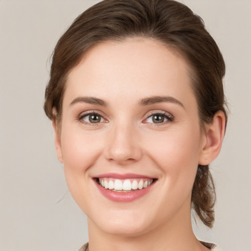 Joyful white young-adult female with medium  brown hair and green eyes