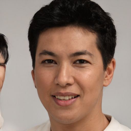 Joyful asian young-adult male with short  brown hair and brown eyes