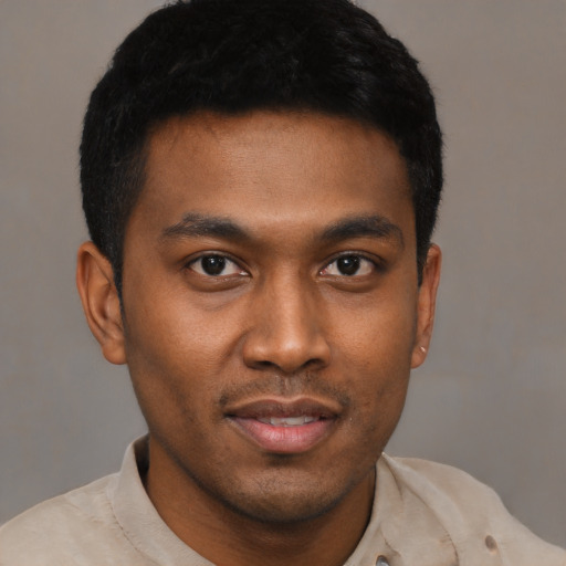 Joyful black young-adult male with short  black hair and brown eyes