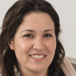 Joyful white adult female with long  brown hair and brown eyes