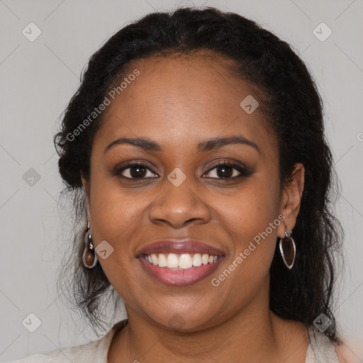 Joyful black young-adult female with long  brown hair and brown eyes