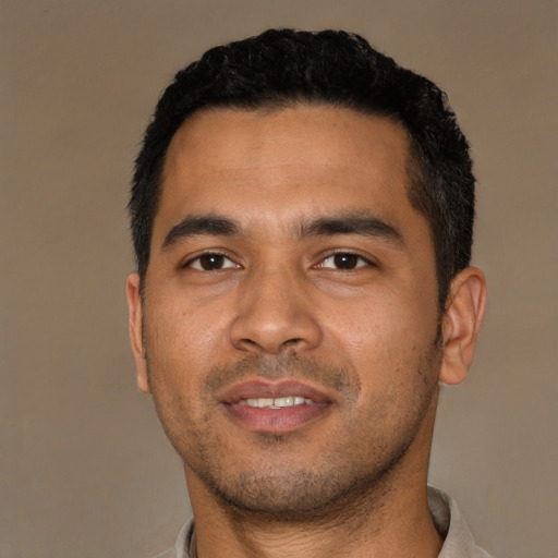 Joyful latino young-adult male with short  black hair and brown eyes