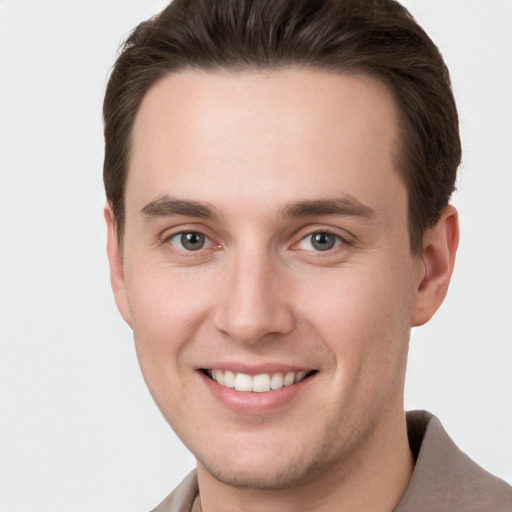 Joyful white young-adult male with short  brown hair and grey eyes