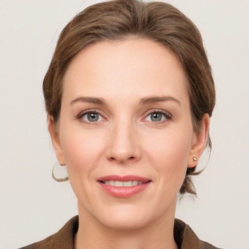 Joyful white young-adult female with medium  brown hair and grey eyes