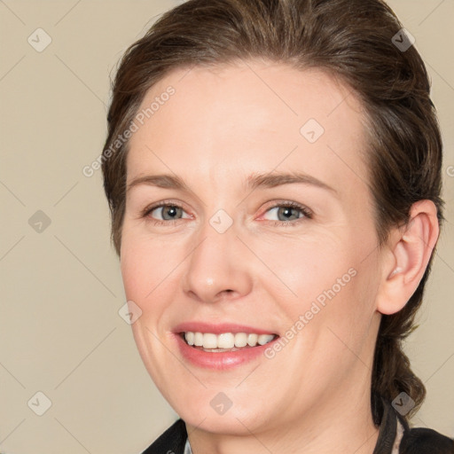 Joyful white adult female with medium  brown hair and grey eyes